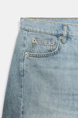 Bermuda de denim color marrón oscuro, de tiro medio y diseño relaxed fit, con cinco bolsillos, trabillas para cinto, bajo desflecado y cierre frontal con cremallera y botón.