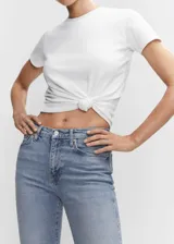 Pantalón jean de corte ajustado y tiro alto, en tono azul claro con efecto deslavado y diseño tobillero.