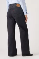 Jean de corte loose boot, tiro medio, color negro, con diseño de cinco bolsillos y cierre frontal con botón y cremallera.