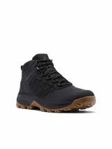 Bota de trekking Columbia modelo Transverse Hike, de color negro con suela de caucho marrón, confeccionada en malla y piel con tecnología impermeable y transpirable.