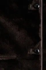 Chaqueta de textura suave efecto peludito en color marrón oscuro, con cuello redondo, cierre frontal mediante botones y bolsillos laterales ribeteados.