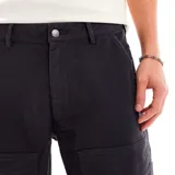 Pantalón negro de algodón con bolsillos tipo cargo y logo de Nike bordado en el muslo. Corte relajado.
