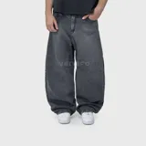 Pantalón de jean con corte ultra baggy, de tiro medio y diseño holgado en las piernas. Presenta un lavado negro desgastado y textura rústica.