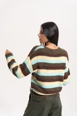 Buzo tejido de calce relajado con diseño de rayas horizontales en tonos marrón, crema y celeste. Presenta cuello redondo, mangas largas y terminaciones acanaladas en puños y cintura.