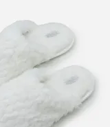 Pantufla cerrada de mujer con textura de peluche suave en color negro, diseñada para brindar comodidad en el hogar.