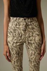 Pantalon de jean con corte flare y tiro alto, estampado con diseño animal print de leopardo en tonos marrones. Cuenta con bolsillos funcionales y ruedo desflecado.
