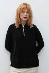 Sweater de pana color marrón con cuello polo y cierre frontal parcial. Presenta un diseño de corte holgado, mangas largas con puños elásticos y textura acanalada.