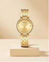 Reloj analógico de mujer con caja redonda y malla de eslabones metálicos, acabado en tono dorado. Presenta una esfera minimalista con marcadores de hora y detalles brillantes.