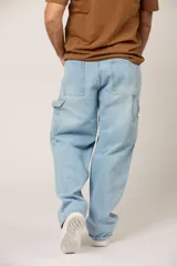Jean de corte baggy en denim color celeste claro, con diseño de paneles reforzados en la parte frontal y estilo cargo con bolsillos laterales.