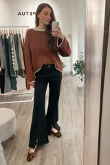 Jean negro de corte wide leg con tajo frontal y tiro medio alto.