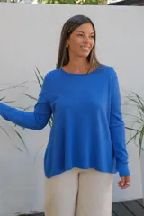 Sweater de punto color azul, con cuello redondo, manga larga y corte holgado con ruedo asimétrico.