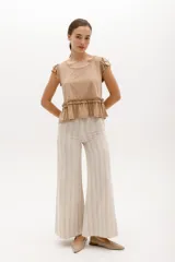 Remera de algodón y lyocell color beige, con cuello redondo, mangas cortas con volados y detalle de frunce con volado en la cintura.
