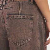 Pantalón de jean estilo barrel con efecto acid wash en tonos marrones y rosados, tiro medio y corte holgado en las piernas.