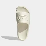 Ojotas Adidas modelo Campus 00s, confeccionadas en una sola pieza de espuma sintética color beige. Presentan un diseño minimalista con el logo Campus 00s grabado en la banda superior y suela con ranuras para mayor agarre.