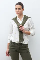 Camisa blanca de manga larga con cuello abotonado y estampado de pequeñas flores en tonos naranjas y verdes.