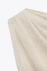 Top de tejido punto color marrón oscuro, con escote asimétrico tipo *one-shoulder* y drapeado frontal.