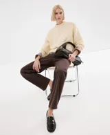 Jeans rectos tiro medio color marrón oscuro con bolsillos clásicos y cierre frontal.