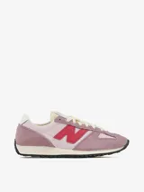 Zapatillas New Balance modelo 4716 de estilo retro running, en tonos rosa y malva con detalles en rojo vibrante. Presentan una combinación de gamuza y material sintético, con el logo N en el lateral y suela de goma dentada.