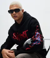 Buzo con capucha de corte relajado, color negro, con estampado frontal y en la manga con el logo de la banda Slipknot en tonos rojos y azules.