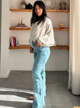 Jean de tiro alto en color azul claro, con costuras verticales frontales que estilizan la silueta y cierre de botones.