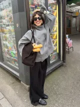 Chaqueta de paño color marrón oscuro, con diseño de doble botonadura frontal y cuello alto estructurado. Presenta mangas largas y un corte recto y holgado.