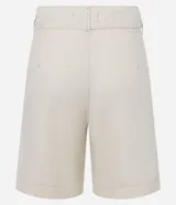 Bermuda de cintura mediana color beige, confeccionada en sarga, con trabillas, cierre tradicional, bolsillos y frisos delanteros. Incluye cinturón de tejido para lazo con hebilla metalizada.