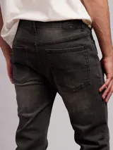 Jean de corte recto y tiro medio, confeccionado en denim con efecto lavado desgastado en tono gris oscuro.
