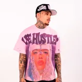 Camiseta oversize de manga corta color rosado con diseño gráfico frontal que incluye rostro con detalles de cristales y letras grandes texturizadas con apliques brillantes.