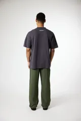 Remera de algodón de corte holgado, color blanco crema, con cuello redondo y pequeño parche bordado en el pecho.