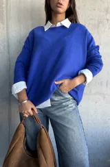 Sweater de punto color azul, de corte oversize, con cuello redondo y mangas largas.