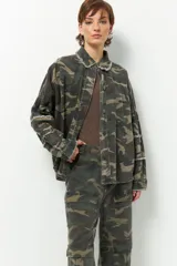 Sobrecamisa de estilo militar con estampado de camuflaje, cuello clásico, cierre frontal con botones y mangas largas. Presenta detalle de flecos en cuello, mangas y espalda.