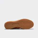 Zapatillas tipo ballerina Converse, color rojo, confeccionadas en lona con revestimientos de gamuza. Presentan una banda elástica en el empeine, suela de goma dentada color caramelo y el logo de la marca en el lateral.