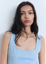 Vestido corto entallado de color celeste, con escote cuadrado y tirantes anchos. Presenta un diseño minimalista con costuras verticales decorativas.