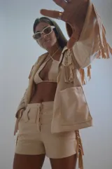 Campera color beige de gamuza sintética con flecos en mangas, espalda y ruedo.