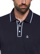 Polo azul marino de manga corta en tejido interlock, con cuello clásico, tapeta con botones, bolsillo en el pecho y logo bordado. Detalles de ribete blanco en cuello y mangas.
