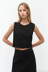 Top corto negro sin mangas con escote redondo.