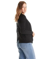 Cardigan de tejido liviano en color beige, con frente abierto y solapas tipo cascada. Presenta mangas largas entalladas con puños de rib y detalle de botones en la espalda.