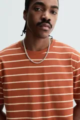 Remera color arena de corte recto, cuello redondo y mangas cortas.