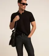 Pantalón de jean negro, modelo slim, con bolsillos laterales.