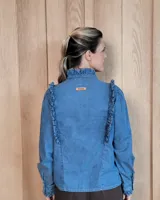 Camisa de denim negro con cuello alto, cierre frontal de botones y detalles de volados en el frente y puños.