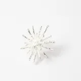 Anillo de diseño orgánico con forma de estrella o erizo, acabado en color plateado con textura irregular.