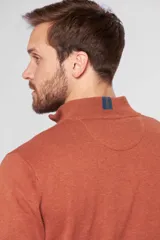 Buzo liso de punto fino en hilo de algodón color azul marino, con cuello alto y cierre frontal parcial con detalle de tirador de cuero.