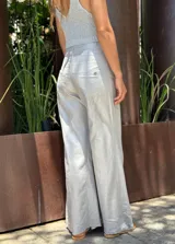 Pantalón blanco de corte palazzo, tiro alto y cintura elástica. Confeccionado en tela ligera con textura.