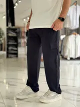Pantalón jogging cargo color negro, sin felpa, liviano y de corte oversize, con bolsillos laterales en las piernas.
