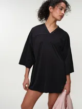 Remera deportiva de manga corta rosada, con escote en V y corte oversized de tejido dry fit.