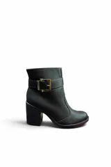 Bota corta de cuero color negro, con taco cuadrado y puntera redondeada. Cuenta con una tira con hebilla metálica plateada alrededor del tobillo y costuras visibles a contratono.