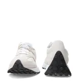 Championes urbanos New Balance modelo 327, con diseño retro en tonos beige y blanco. Presentan una combinación de materiales en gamuza y nylon, con el logo N característico en el lateral y una suela de goma con relieve que se extiende hacia el talón.
