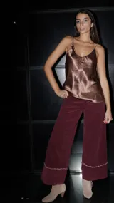 Pantalón tipo palazzo de pana color tostado, con corte amplio y detalle de ruedo deshilachado.