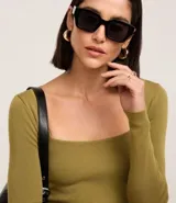 Blusa negra de punto leve, con corte ajustado, escote cuadrado y mangas largas.