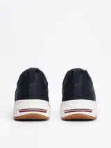 Zapatillas Tommy Hilfiger de running, color azul marino, con exterior de punto y poliéster, suela de goma blanca y detalles distintivos de la marca en el talón.